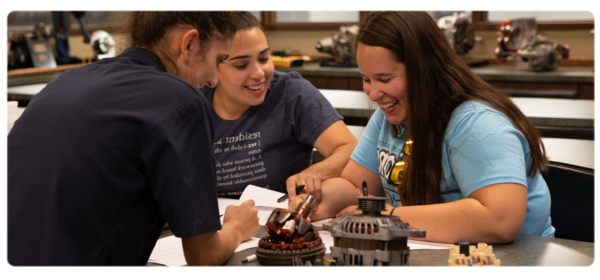 Three students work on an automotive assignment